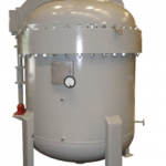 Gray industrial pressure vessel with a rounded top, side-mounted pressure gauge, and multiple fittings, supported by four legs.